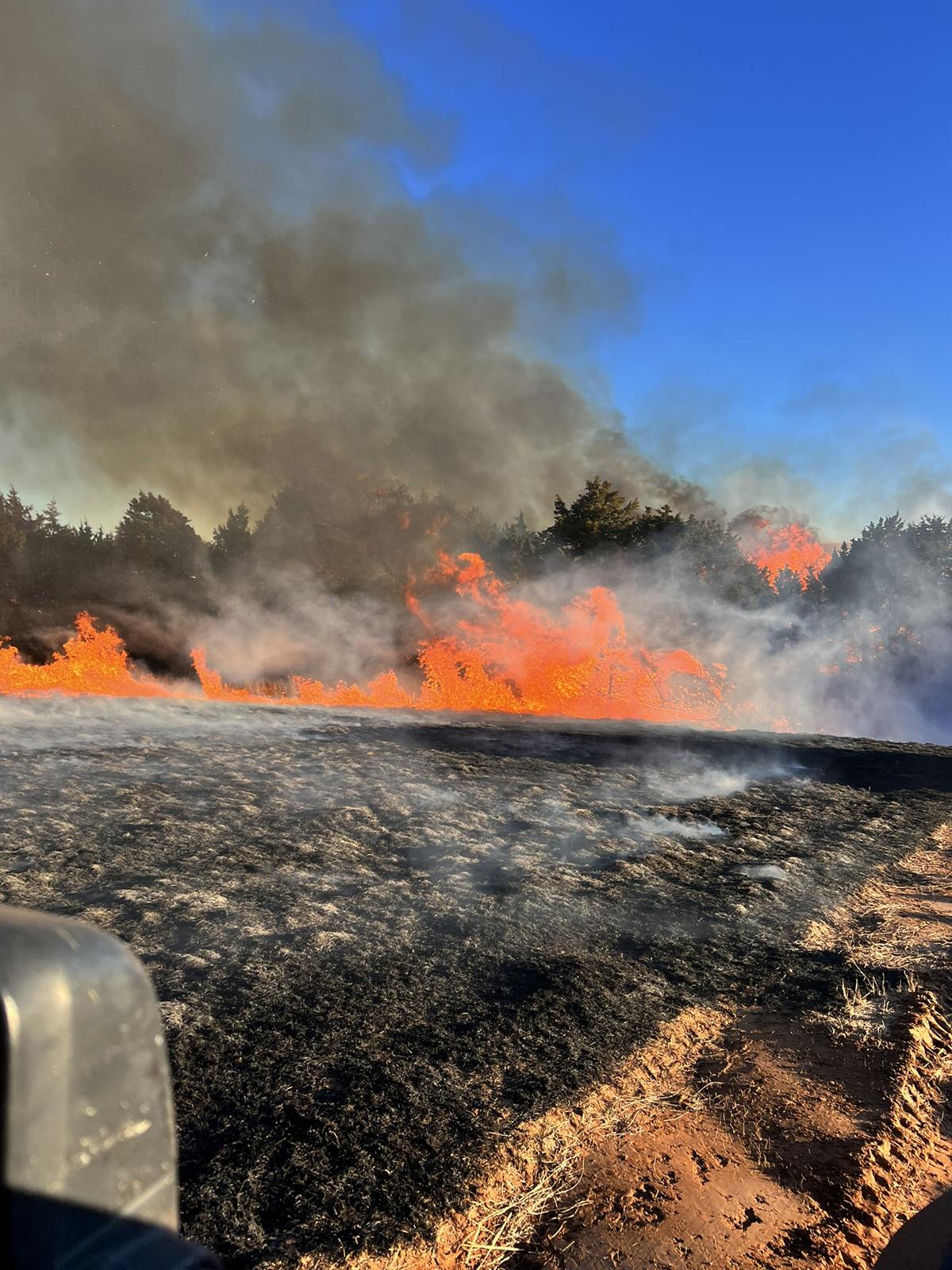 Wildfire burning across a field at night in western Oklahoma