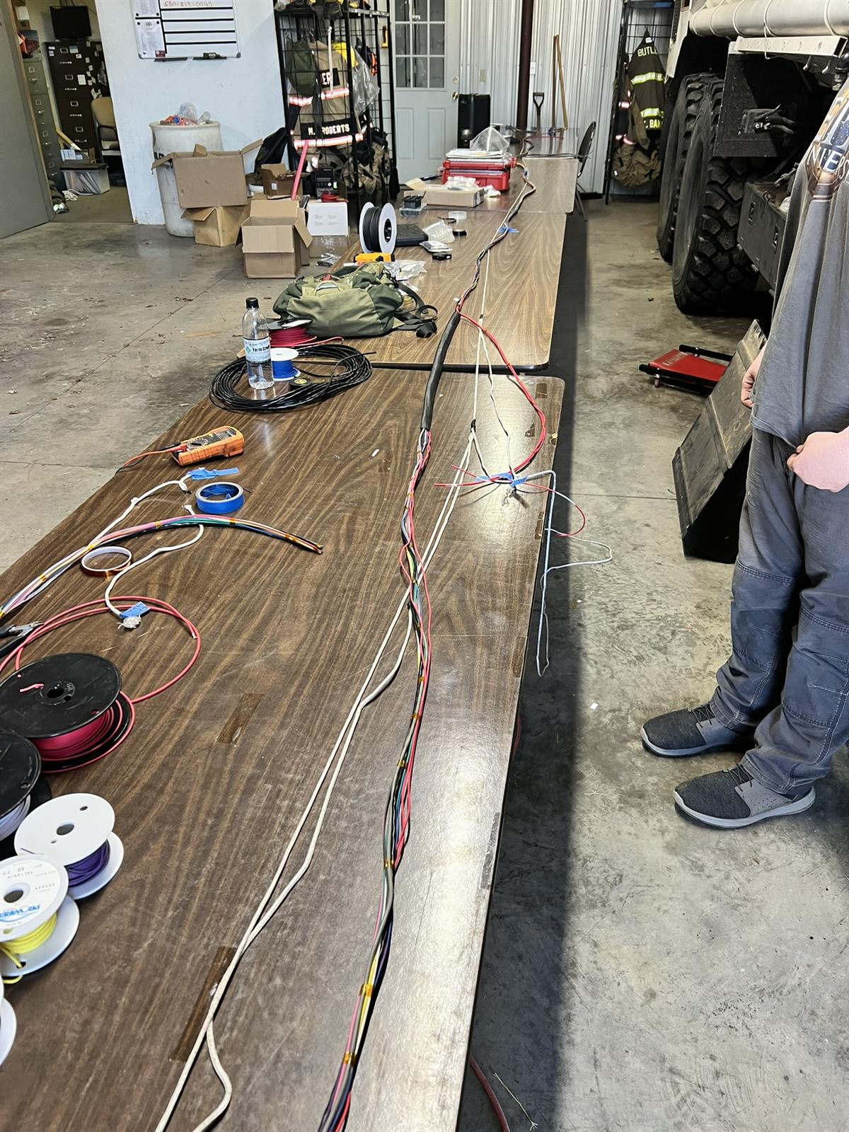 Long wiring harness laid out across the build bench