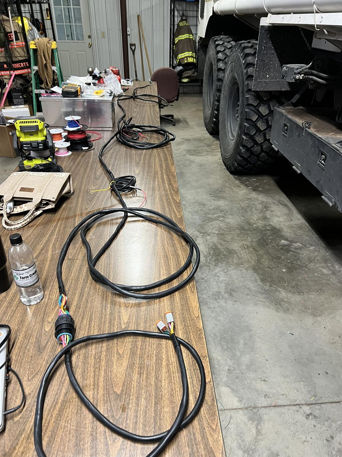 Custom wiring harnesses laid out next to a truck