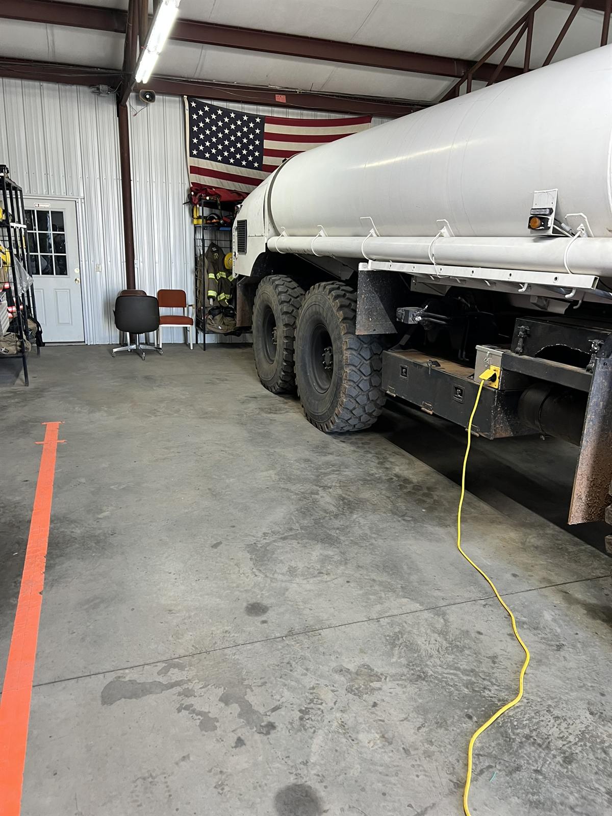 Tanker truck in the build bay beneath an American flag